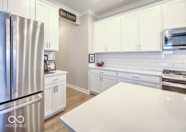 kitchen with appliances with stainless steel finishes, crown molding, backsplash, light wood-type flooring, and white cabinetry