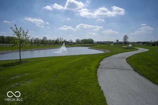 surrounding community featuring a water view and a lawn