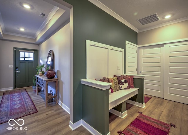 foyer entrance with ornamental molding, wood finished floors, baseboards, a tray ceiling, and recessed lighting