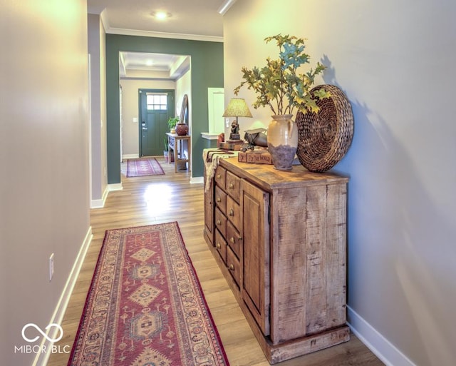 corridor with crown molding, light wood-style floors, and baseboards