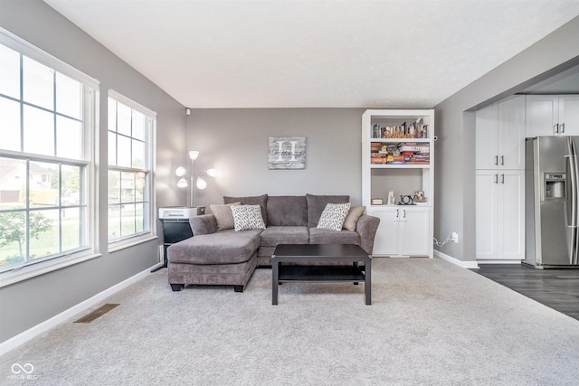 carpeted living room featuring baseboards