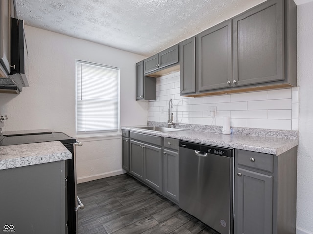 kitchen featuring stainless steel dishwasher, a sink, gray cabinets, range with electric cooktop, and baseboards