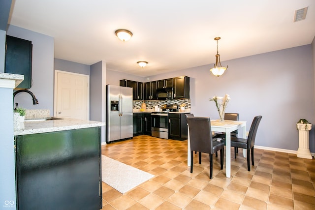 1404 Norton Dr, Greenwood, IN 46143 - kitchen with stainless steel appliances, a sink, decorative backsplash, hanging light fixtures, and light stone counters