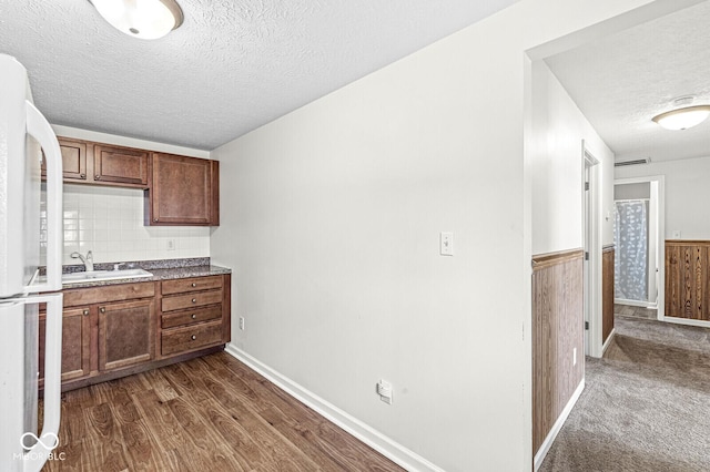 1391 N Shadeland Ave, Indianapolis, IN 46219 - kitchen featuring a textured ceiling, a sink, freestanding refrigerator, dark wood-style floors, and wainscoting
