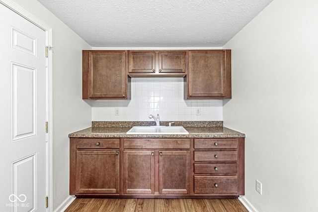 1391 N Shadeland Ave, Indianapolis, IN 46219 - kitchen with a sink, dark countertops, wood finished floors, decorative backsplash, and a textured ceiling
