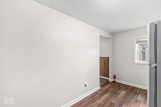 1391 N Shadeland Ave, Indianapolis, IN 46219 - unfurnished room featuring dark wood-style flooring, a textured ceiling, and baseboards