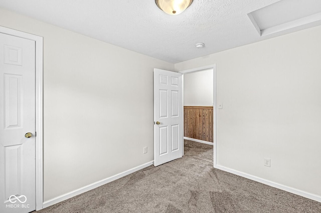 1391 N Shadeland Ave, Indianapolis, IN 46219 - unfurnished bedroom featuring attic access, carpet flooring, baseboards, and a textured ceiling