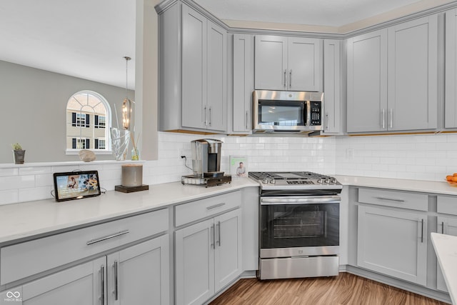 3546 Brampton Ln, Westfield, IN 46074 - kitchen with stainless steel appliances, gray cabinets, light countertops, and decorative backsplash