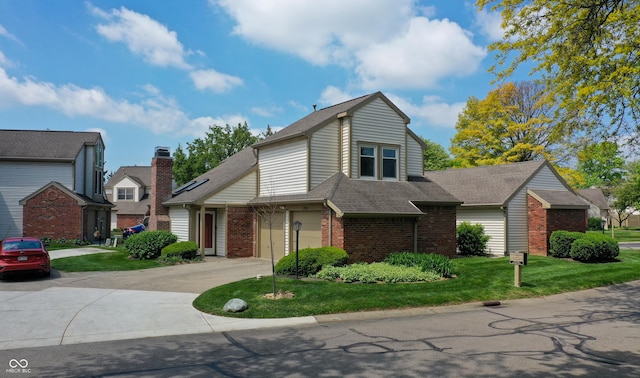 view of front of house with brick siding, a shingled roof, a front lawn, driveway, and an attached garage