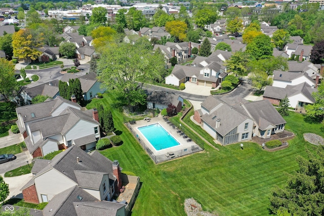 view of property location with a pool and nearby suburban area