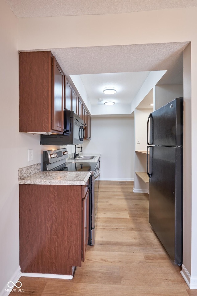 1142 Canterbury Sq S Unit B, Indianapolis, IN 46260 - kitchen with black appliances, light wood-style flooring, light countertops, a sink, and baseboards