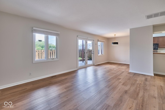 1142 Canterbury Sq S Unit B, Indianapolis, IN 46260 - unfurnished living room with light wood finished floors and baseboards