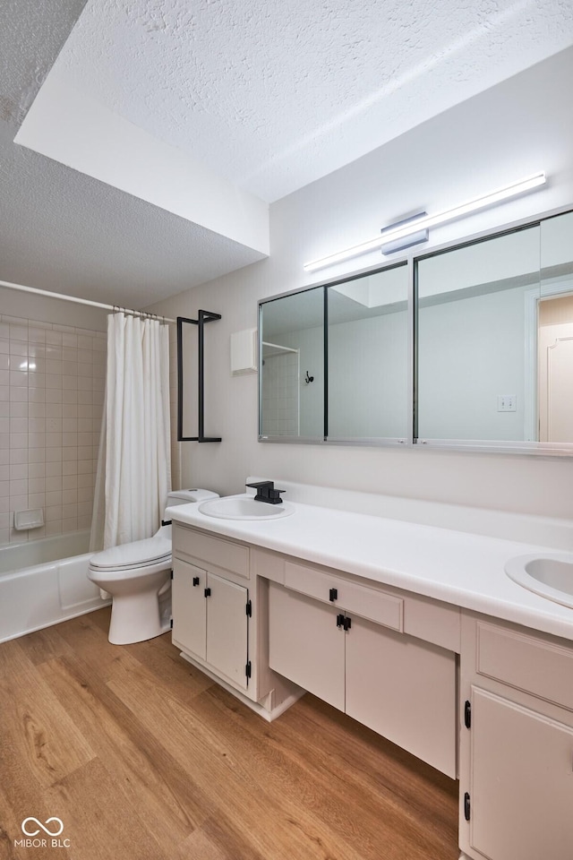 1142 Canterbury Sq S Unit B, Indianapolis, IN 46260 - bathroom with wood finished floors, a textured ceiling, toilet, vanity, and shower / tub combo with curtain