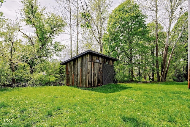 view of green lawn featuring an outbuilding
