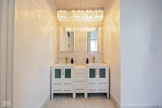 bathroom with a chandelier, backsplash, vanity, and baseboards