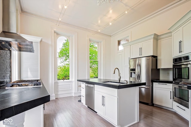 kitchen featuring a sink, stainless steel appliances, dark countertops, and crown molding
