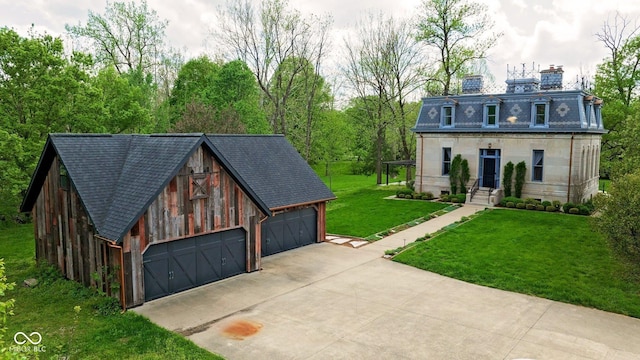 view of front of property featuring a chimney, a front yard, an outbuilding, a garage, and a shingled roof