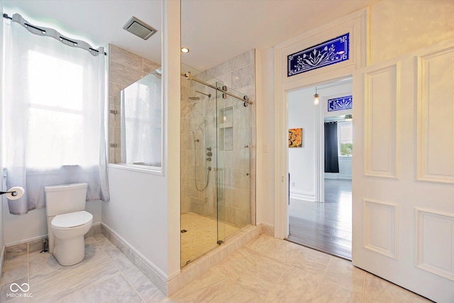full bathroom featuring a stall shower, toilet, and baseboards