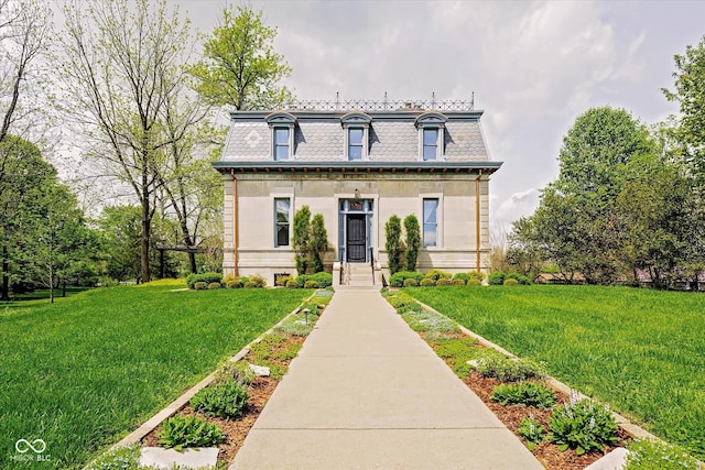 second empire-style home featuring a high end roof, mansard roof, and a front yard