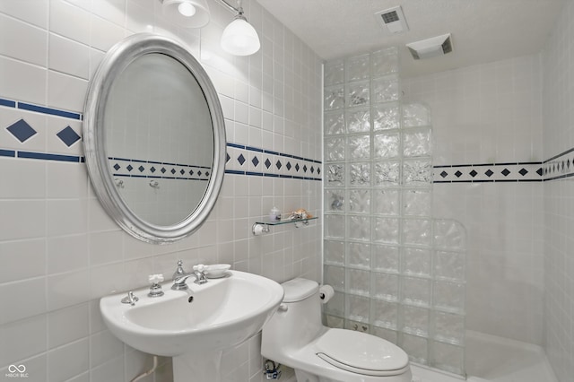 12065 Gray Eagle Dr, Fishers, IN 46037 - bathroom with walk in shower, tile walls, a sink, and toilet