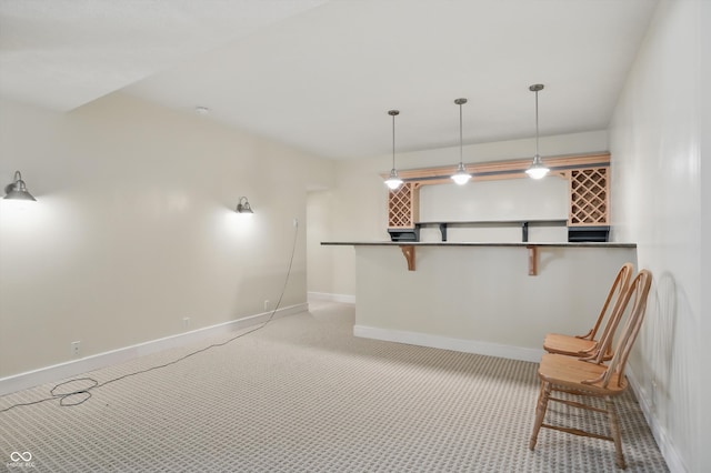 12065 Gray Eagle Dr, Fishers, IN 46037 - interior space featuring baseboards, a breakfast bar area, carpet floors, pendant lighting, and dark countertops