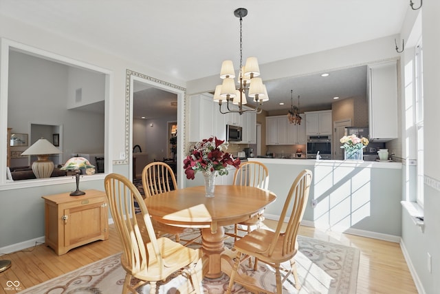 12065 Gray Eagle Dr, Fishers, IN 46037 - dining space with a chandelier, light wood finished floors, and baseboards