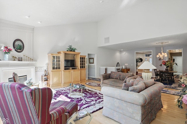 12065 Gray Eagle Dr, Fishers, IN 46037 - living area with light wood finished floors, a chandelier, and high vaulted ceiling