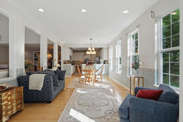 12065 Gray Eagle Dr, Fishers, IN 46037 - living area with light wood finished floors, a chandelier, and recessed lighting