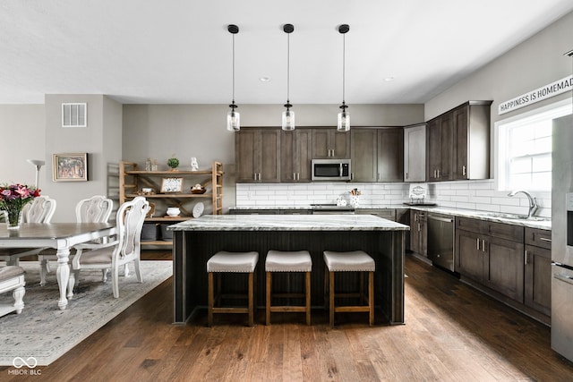 863 N Park Trail Dr, Carmel, IN 46032 - kitchen with appliances with stainless steel finishes, dark brown cabinetry, and a kitchen island