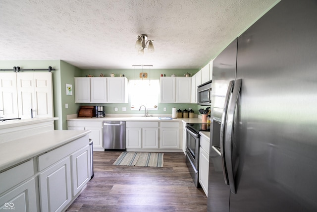 1334 Legacy Ct, Indianapolis, IN 46234 - kitchen with stainless steel appliances, white cabinetry, a sink, light countertops, and a textured ceiling