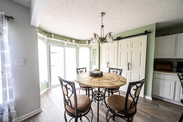 1334 Legacy Ct, Indianapolis, IN 46234 - dining area featuring wood finished floors, a barn door, baseboards, a chandelier, and a textured ceiling