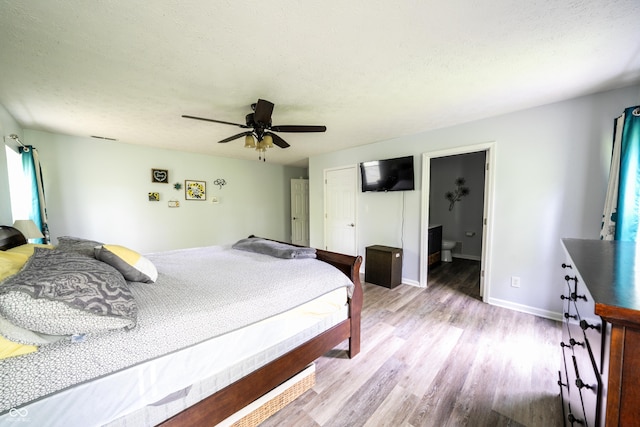 1334 Legacy Ct, Indianapolis, IN 46234 - bedroom featuring wood finished floors, baseboards, a ceiling fan, a textured ceiling, and connected bathroom
