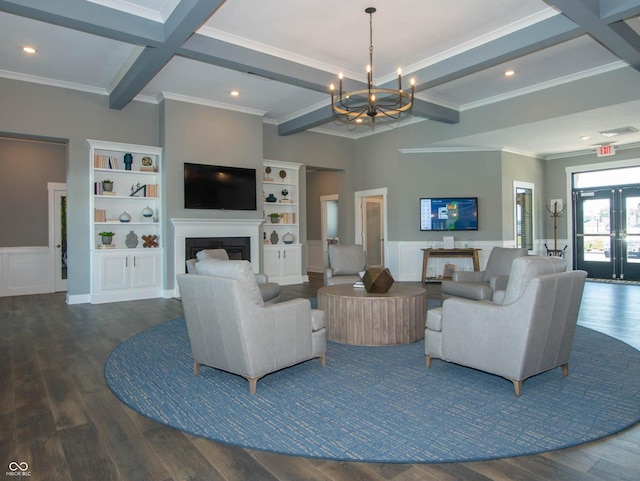 living area with a chandelier, beamed ceiling, a fireplace, wood finished floors, and ornamental molding