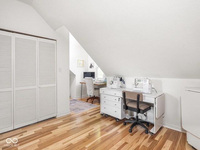 office featuring vaulted ceiling, light wood-style flooring, and baseboards