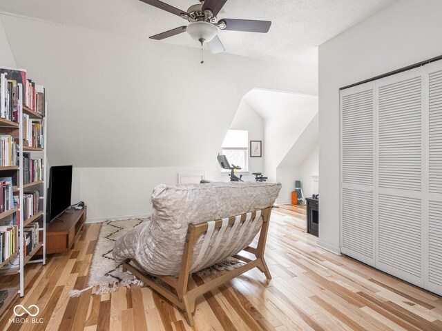 office space featuring light wood finished floors, a ceiling fan, vaulted ceiling, and baseboards
