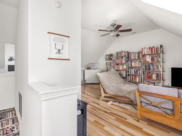 living area with vaulted ceiling, a ceiling fan, and wood finished floors