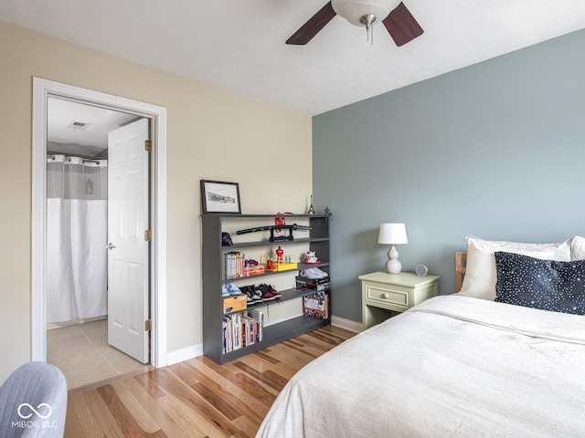 bedroom with wood finished floors, baseboards, and a ceiling fan
