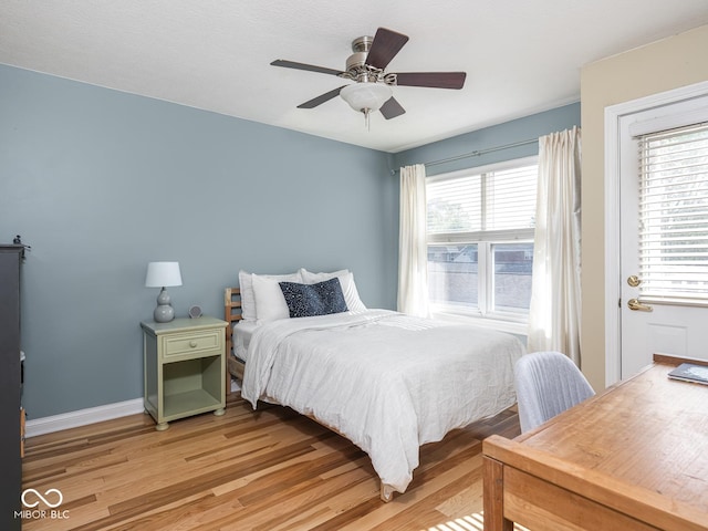 bedroom featuring light wood-type flooring, baseboards, and a ceiling fan