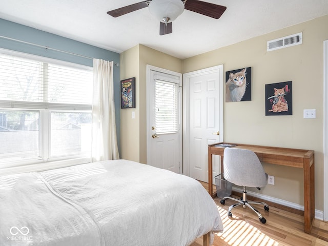 bedroom with wood finished floors, baseboards, and a ceiling fan