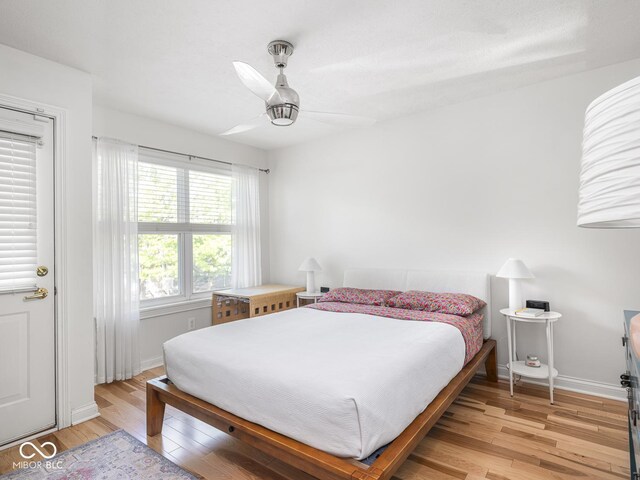 bedroom with light wood-style flooring, baseboards, and a ceiling fan