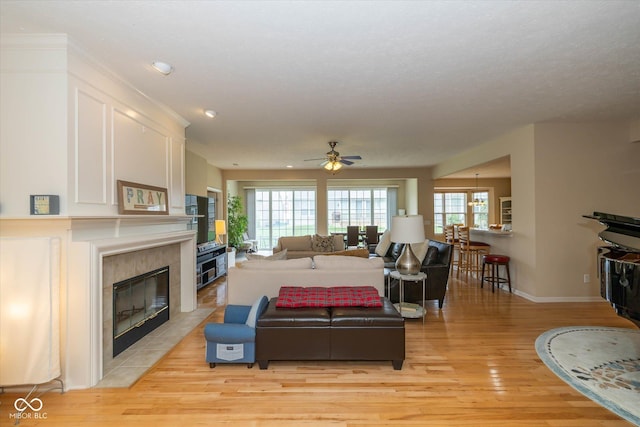 14018 Powder Dr, Carmel, IN 46033 - living room with light wood-style floors, ceiling fan, baseboards, a premium fireplace, and recessed lighting