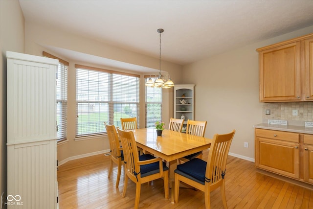 14018 Powder Dr, Carmel, IN 46033 - dining area with light wood-style flooring, a chandelier, and baseboards