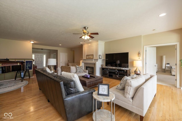 14018 Powder Dr, Carmel, IN 46033 - living room featuring a ceiling fan, light wood-style floors, a fireplace, and recessed lighting