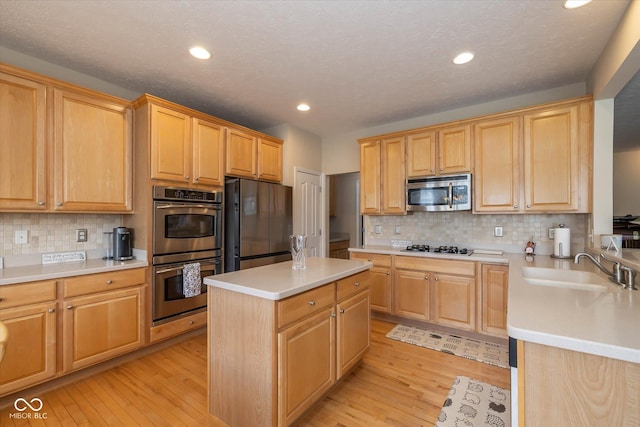 14018 Powder Dr, Carmel, IN 46033 - kitchen featuring appliances with stainless steel finishes, a sink, light wood finished floors, recessed lighting, and decorative backsplash