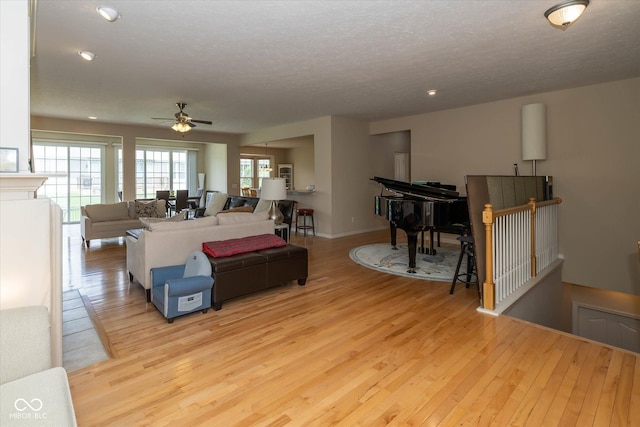 14018 Powder Dr, Carmel, IN 46033 - living room with light wood-style flooring, a ceiling fan, a textured ceiling, recessed lighting, and baseboards