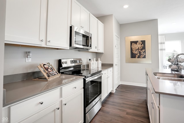 1075 Marston Ln, Avon, IN 46123 - kitchen with stainless steel appliances, a sink, dark wood-type flooring, white cabinets, and baseboards