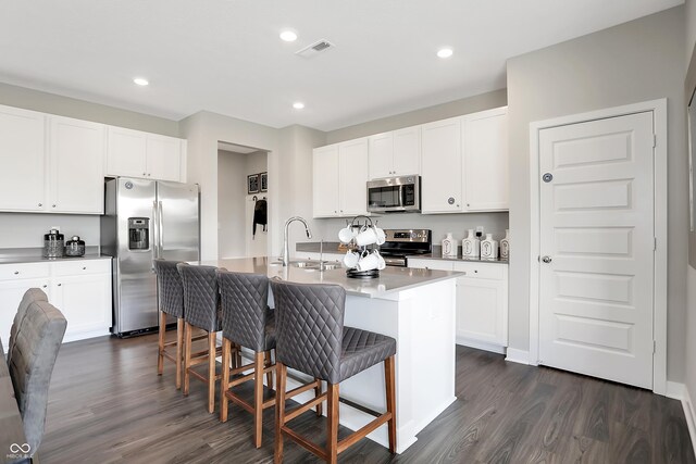 1075 Marston Ln, Avon, IN 46123 - kitchen with appliances with stainless steel finishes, a sink, dark wood-style floors, a kitchen breakfast bar, and a center island with sink