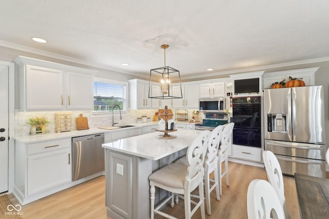 4732 Ferguson Rd, Indianapolis, IN 46239 - kitchen with stainless steel appliances, a sink, white cabinets, decorative backsplash, and light wood finished floors