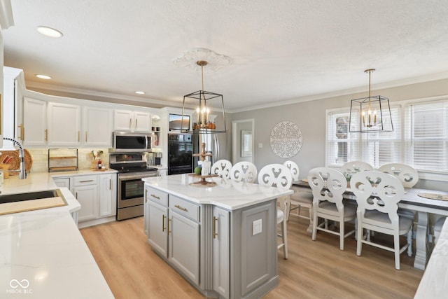 4732 Ferguson Rd, Indianapolis, IN 46239 - kitchen with appliances with stainless steel finishes, a chandelier, a sink, gray cabinets, and crown molding