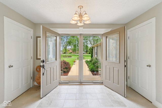 4732 Ferguson Rd, Indianapolis, IN 46239 - foyer entrance with a chandelier, a textured ceiling, and french doors